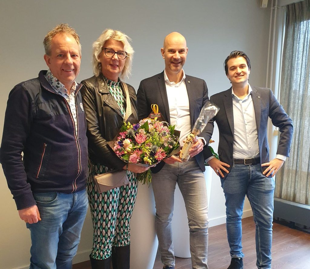 Groep mensen met bloemen en cadeaus.