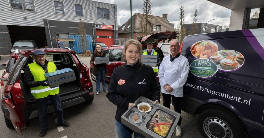 Cateringmedewerkers leveren maaltijden vanuit bestelauto's af.