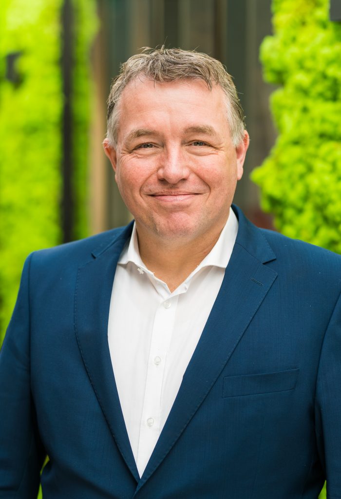 Man in blauwe blazer met groene achtergrond