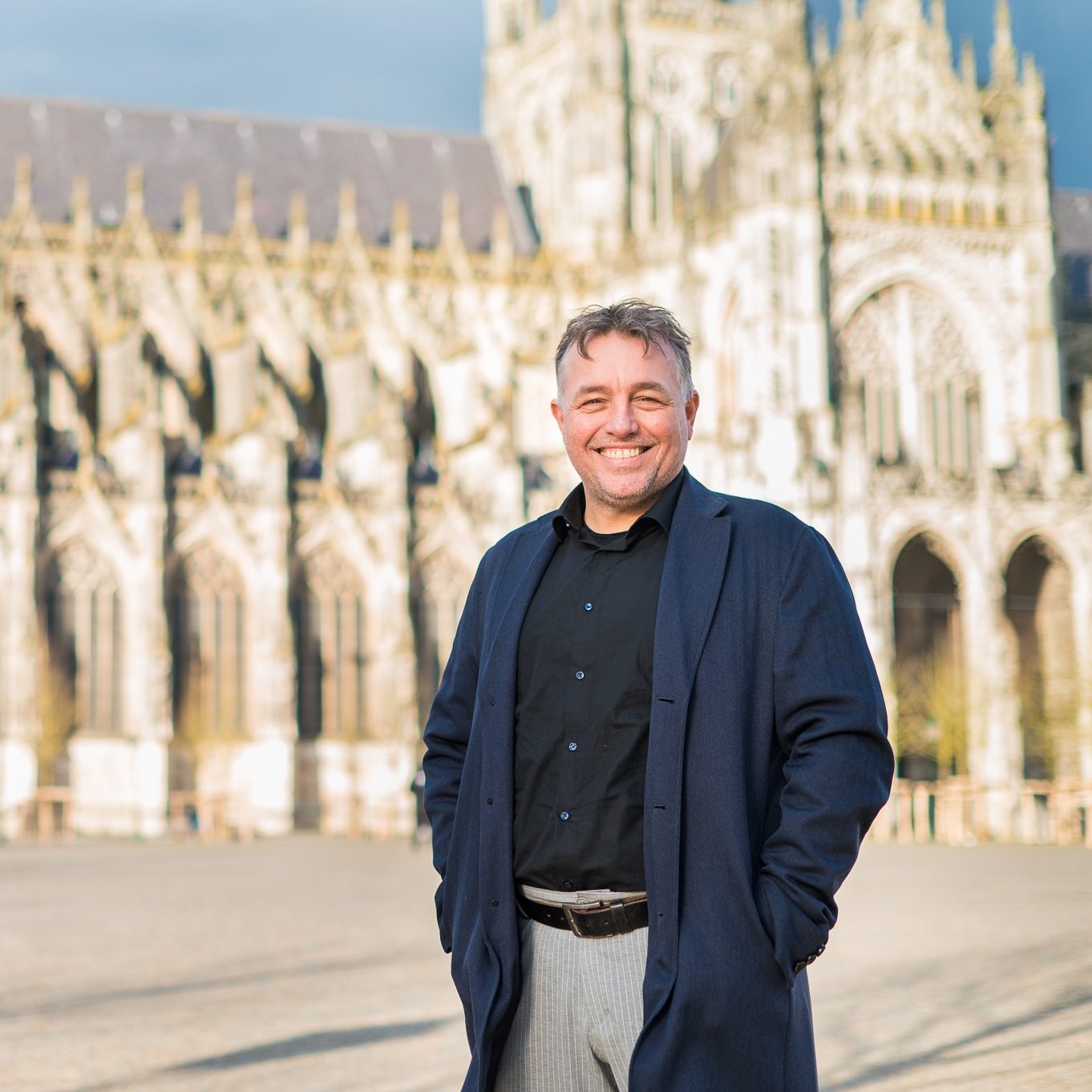 Man poseert voor oude kathedraal.