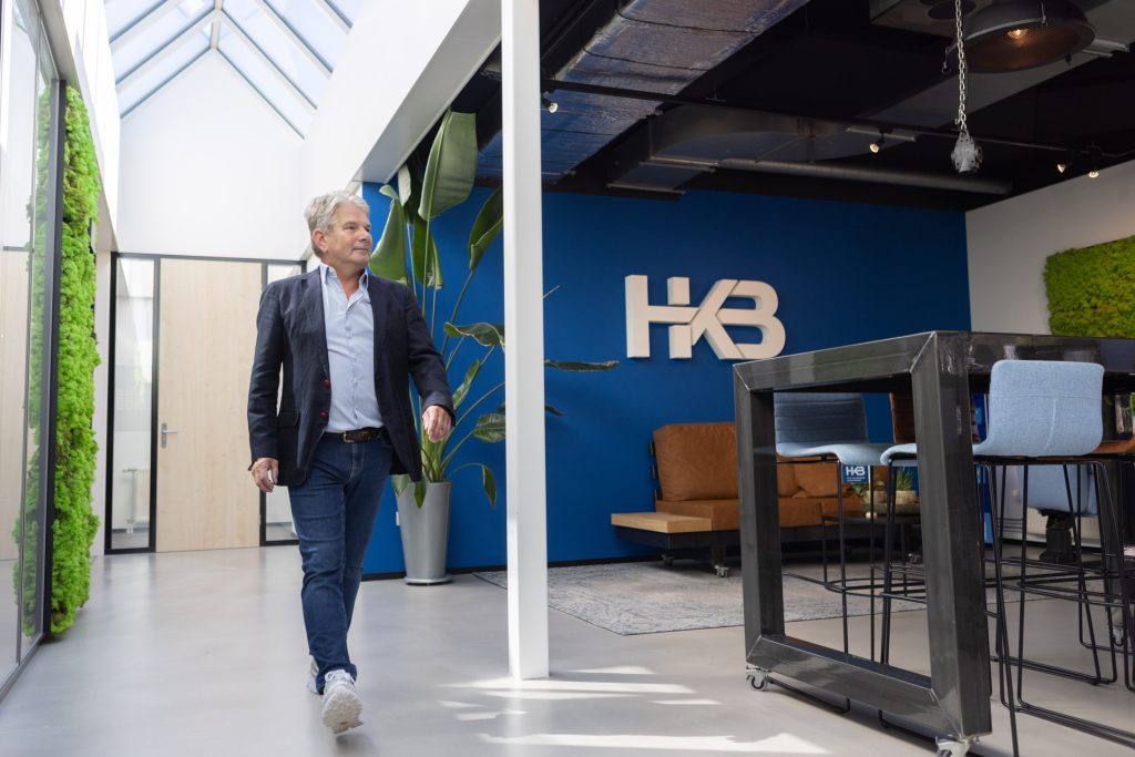 Man loopt door moderne kantoorruimte met planten