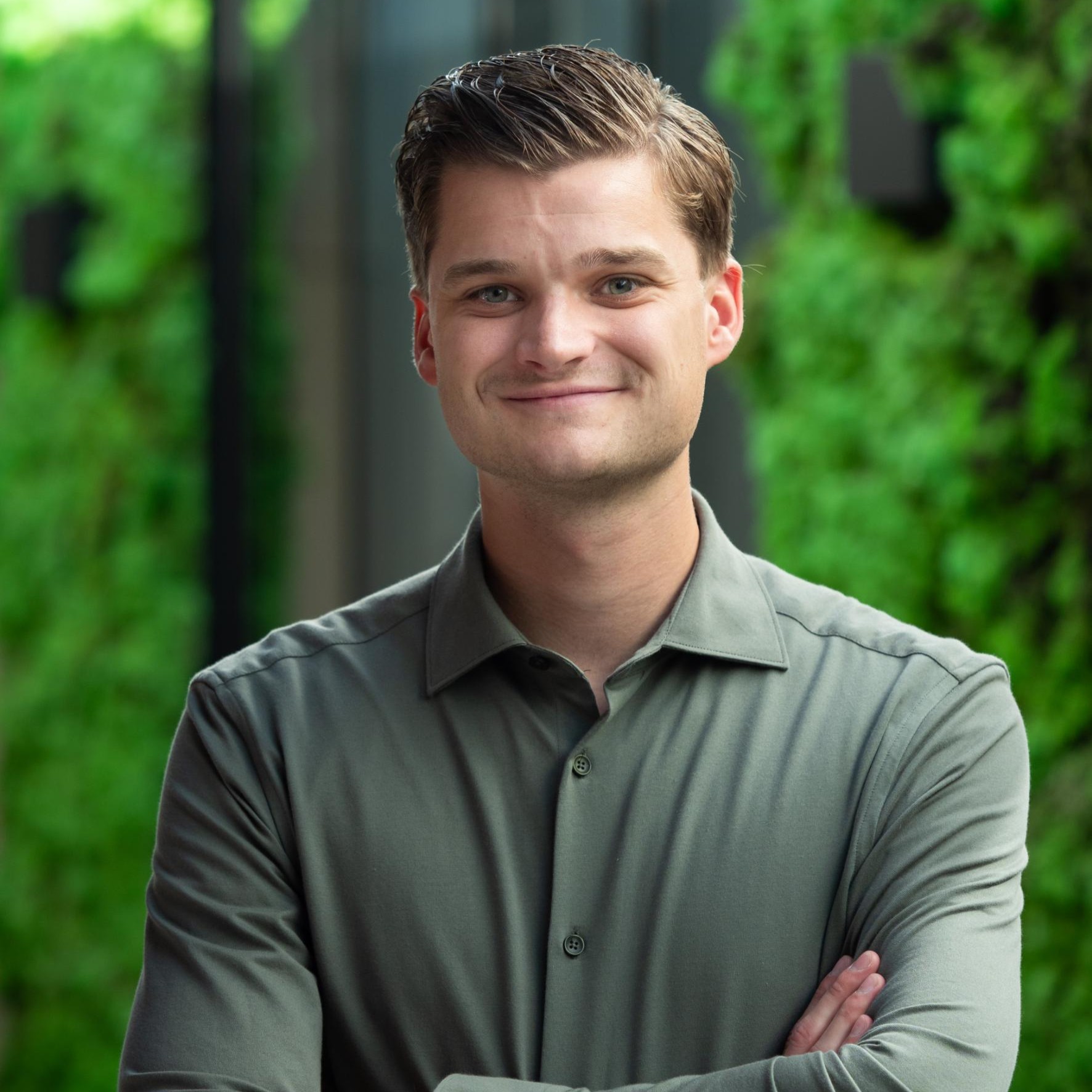 Man met groen blouse voor groene achtergrond.