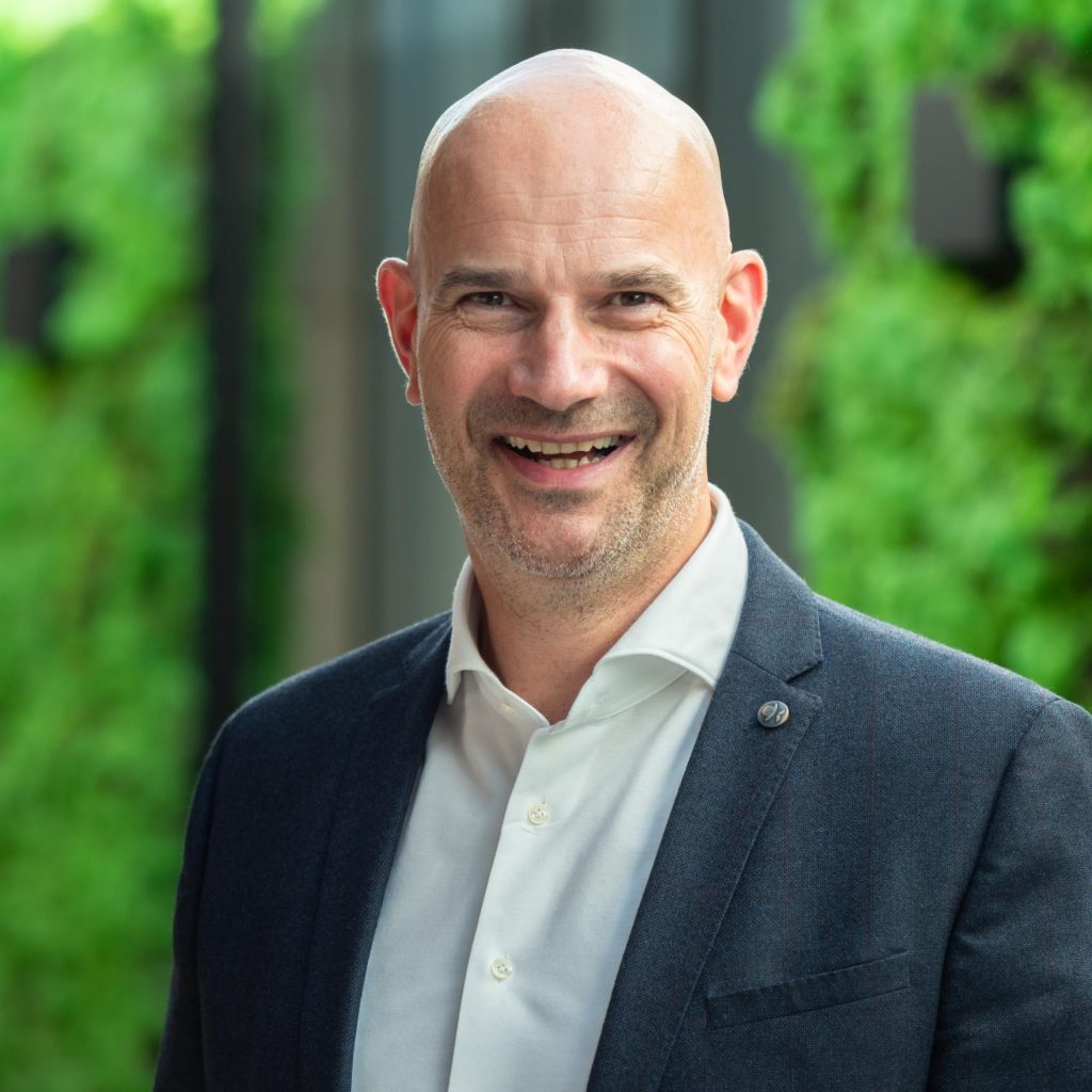 Lachende man in pak met groene achtergrond