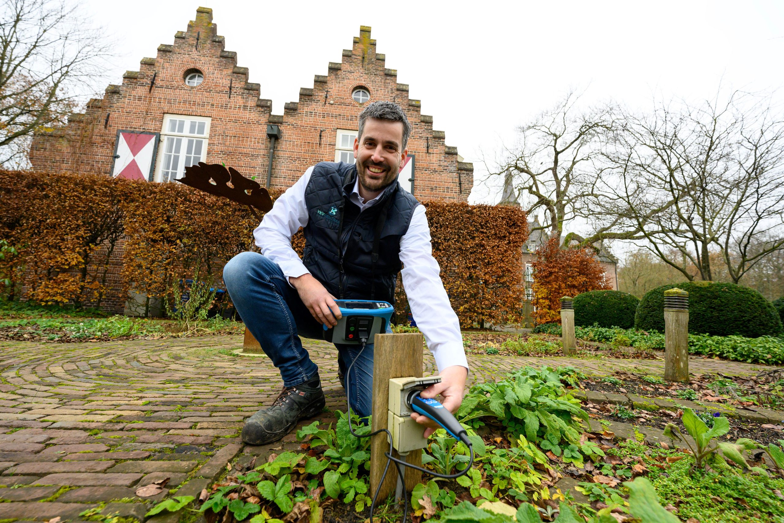 Man controleert elektrische meting in de tuin