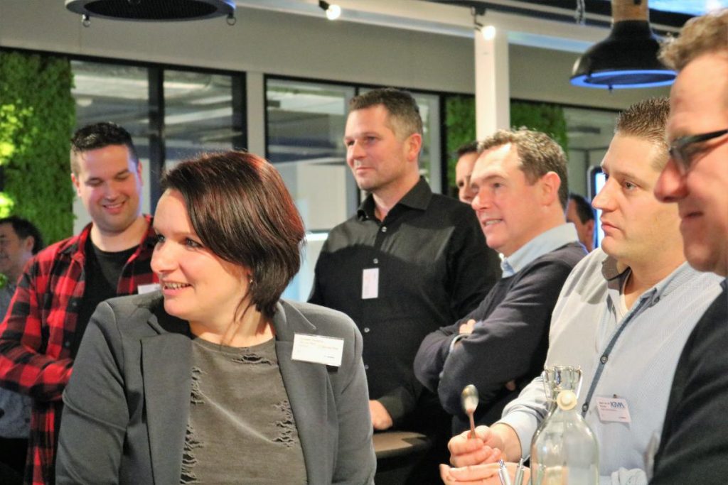 Groep mensen luistert tijdens een bijeenkomst.