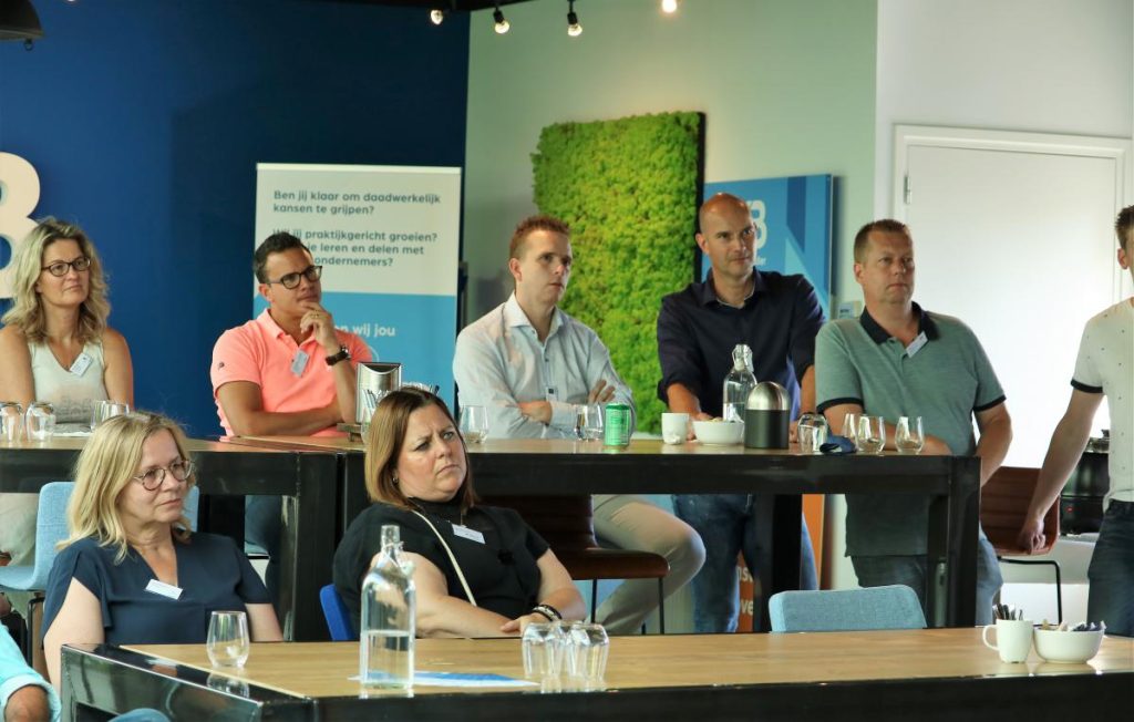 Mensen luisteren aandachtig tijdens een zakelijke presentatie.