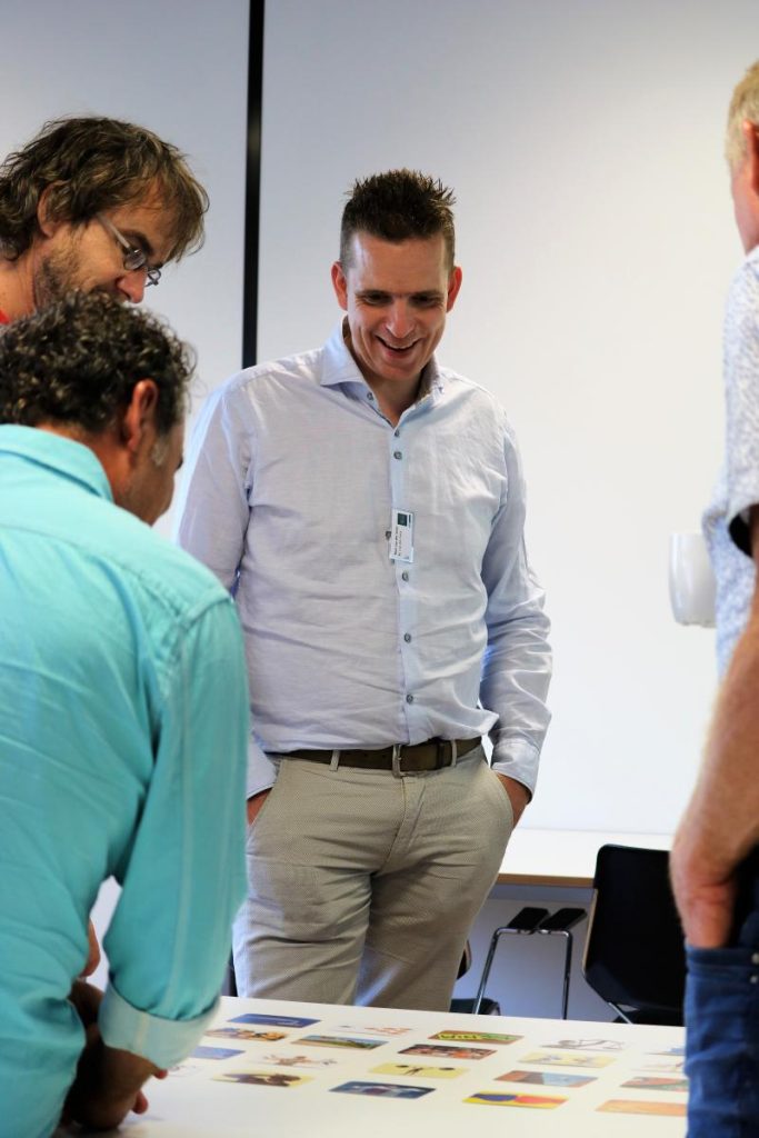 Mensen bespreken kaarten op tafel tijdens bijeenkomst.