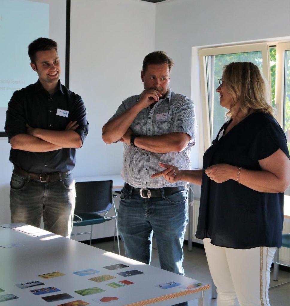 Mensen overleggen bij tafel in vergaderruimte.