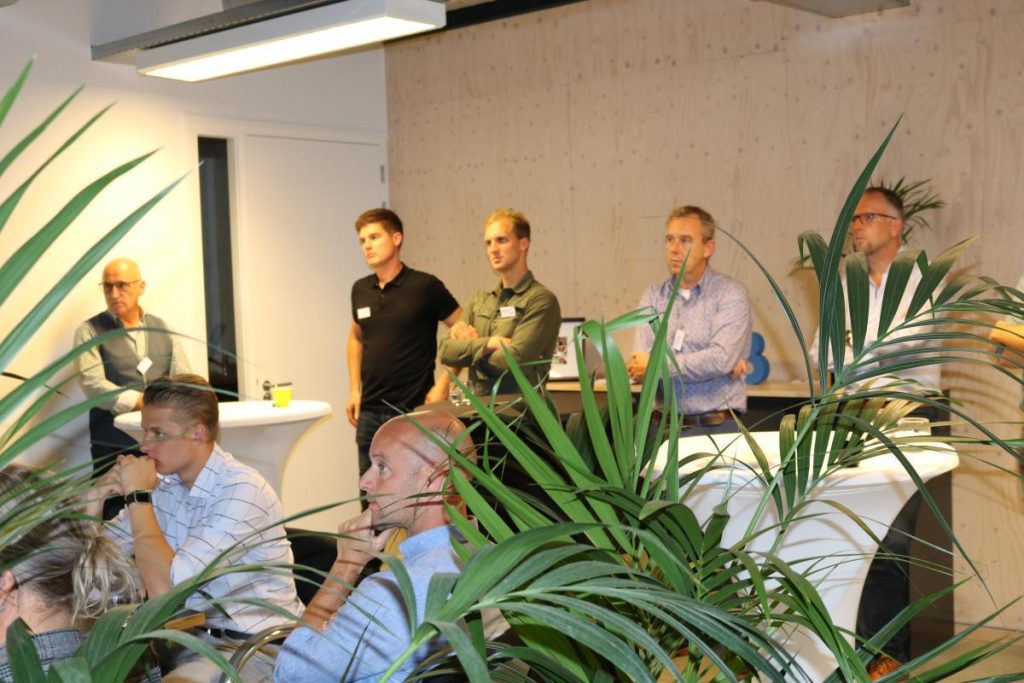 Mensen luisteren tijdens een zakelijke bijeenkomst in een kantoor.