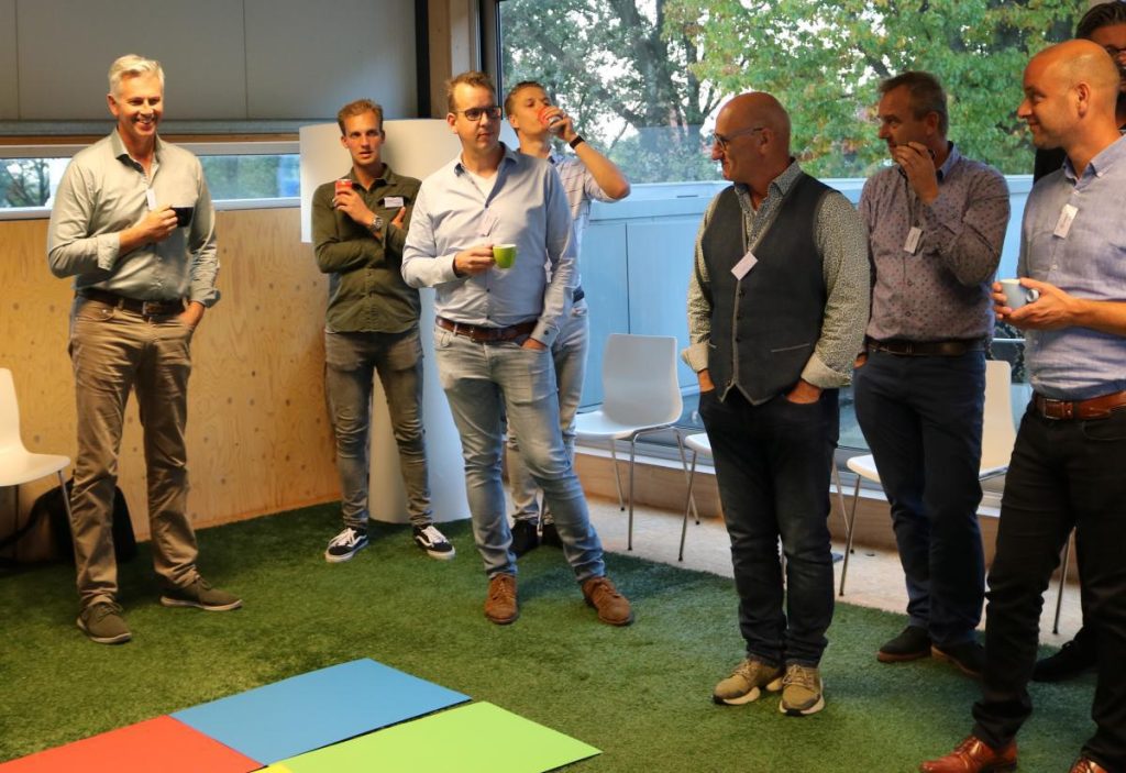 Groep mannen bij bijeenkomst met drankjes.