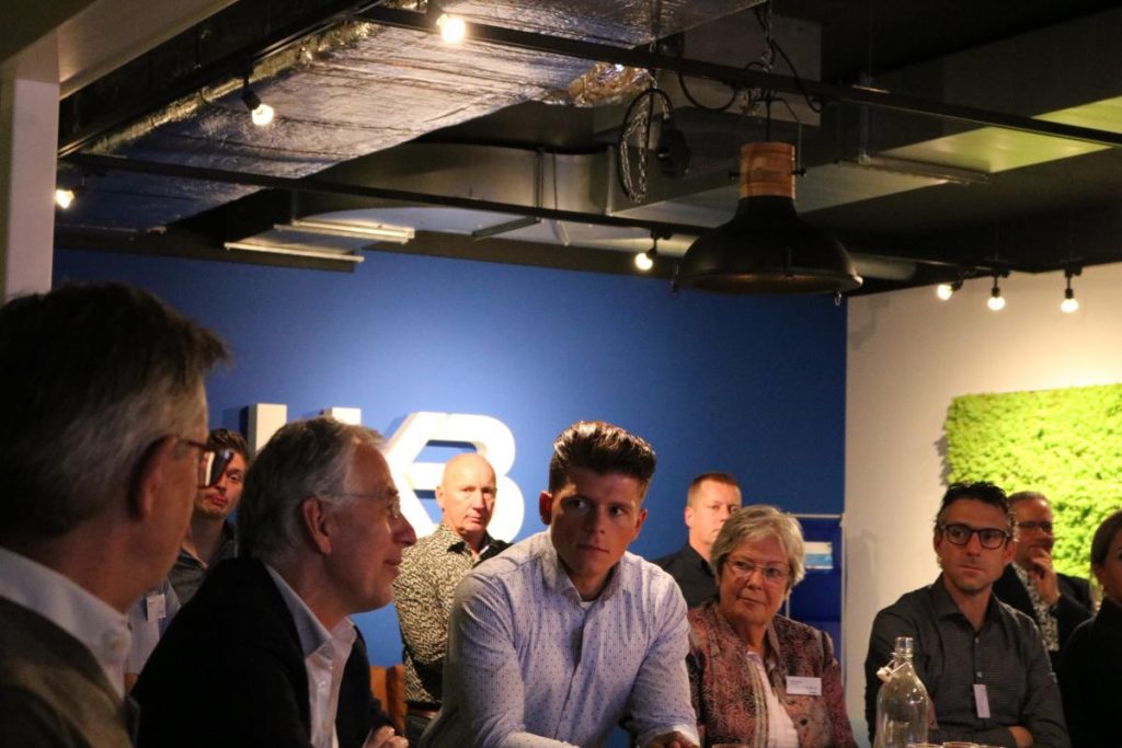 Mensen in discussie tijdens een bijeenkomst in kantoorruimte.