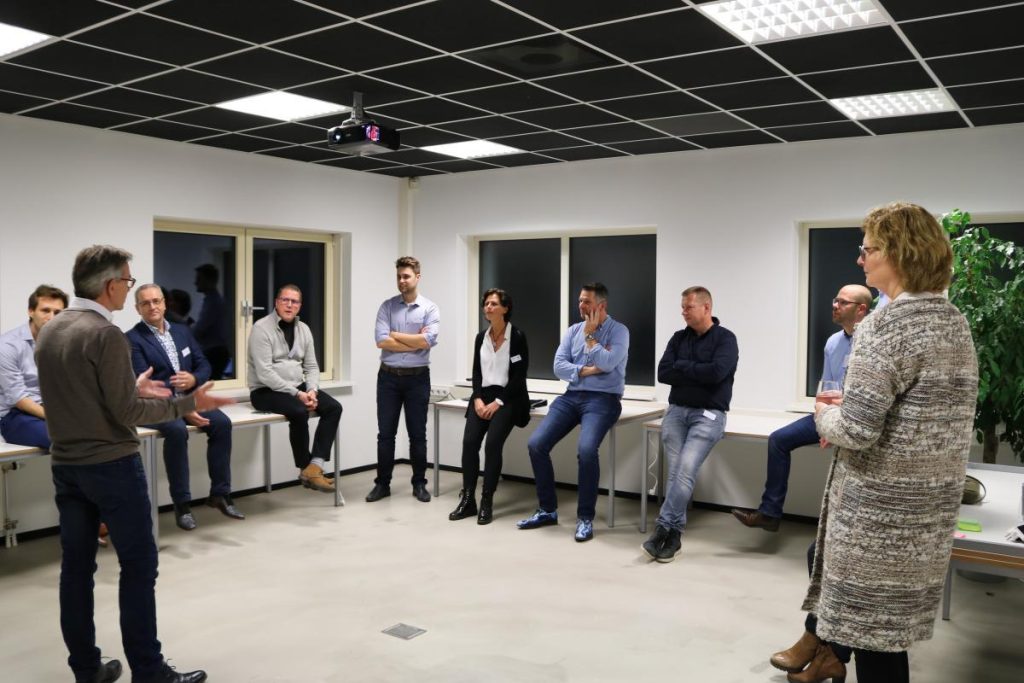 Groep mensen in vergadering in moderne kantoorruimte.