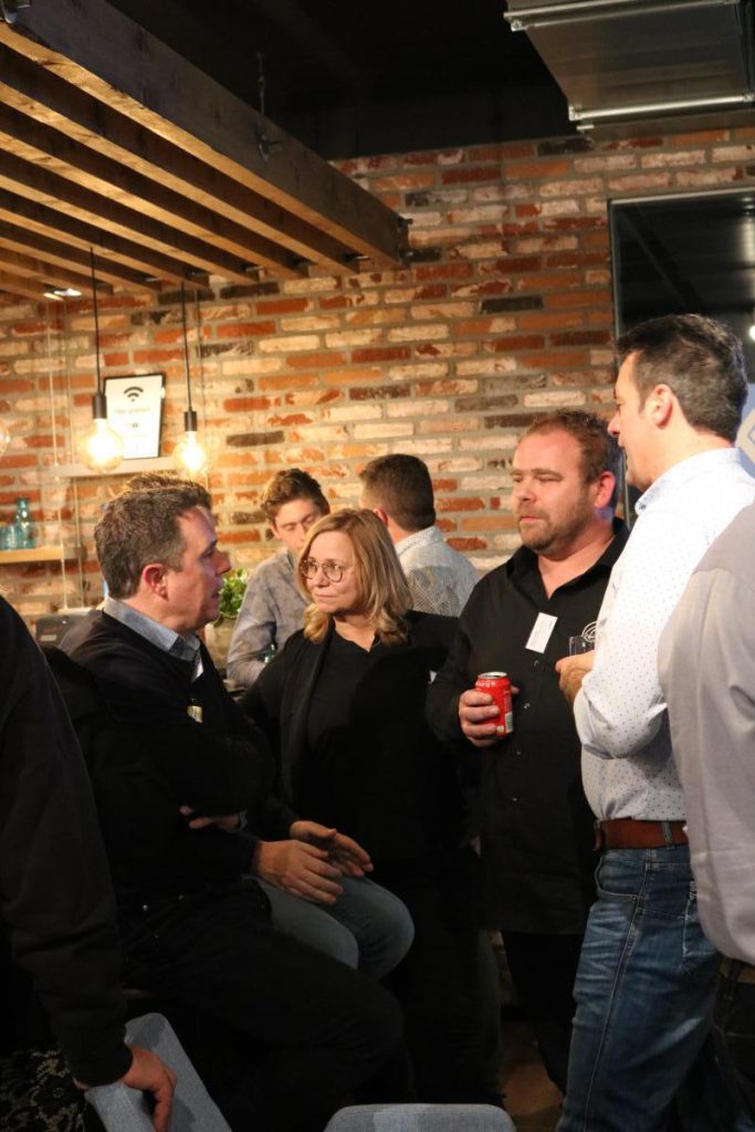 Groep mensen praten tijdens informele bijeenkomst in café.