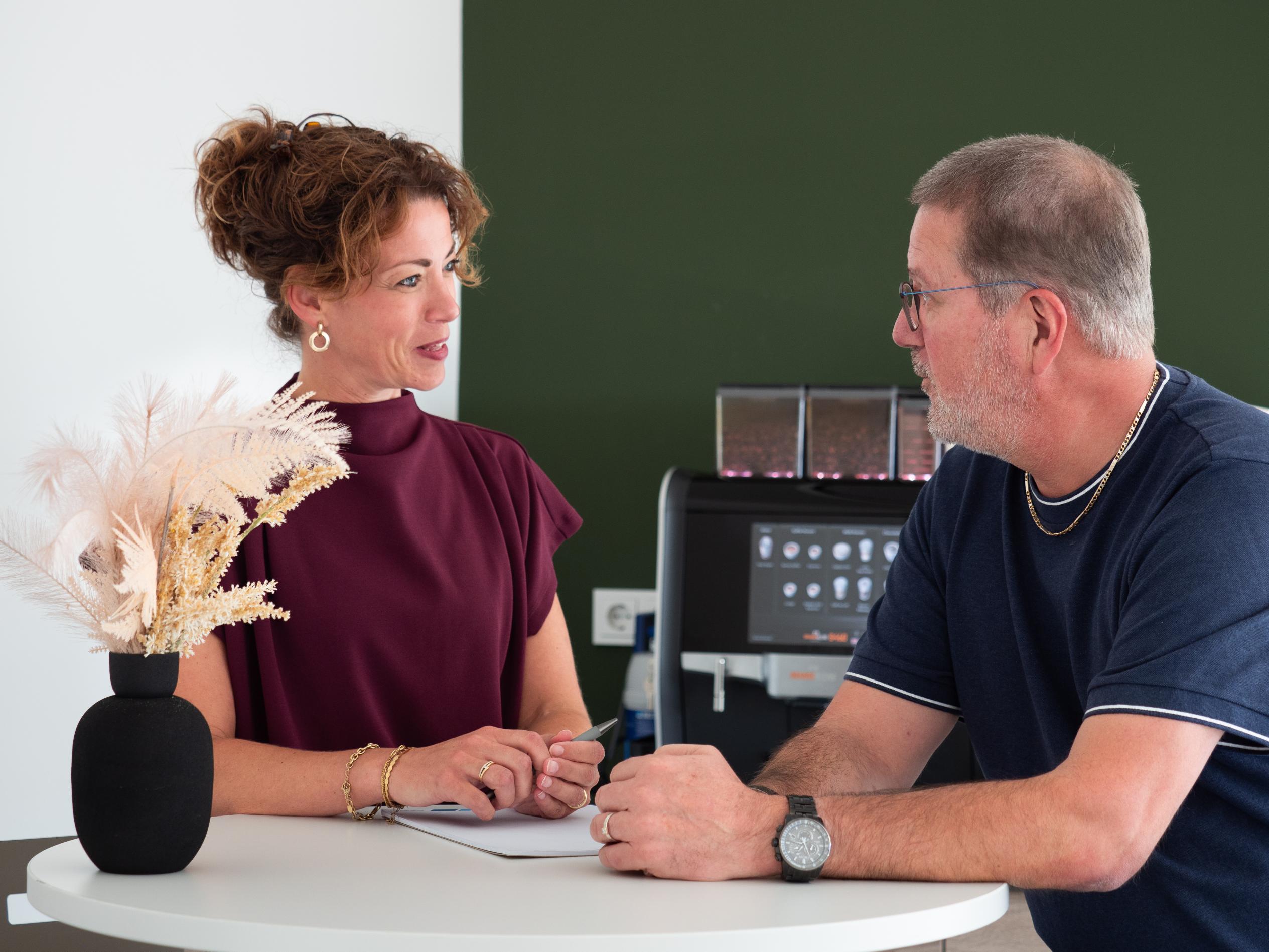 Man en vrouw in gesprek bij tafel