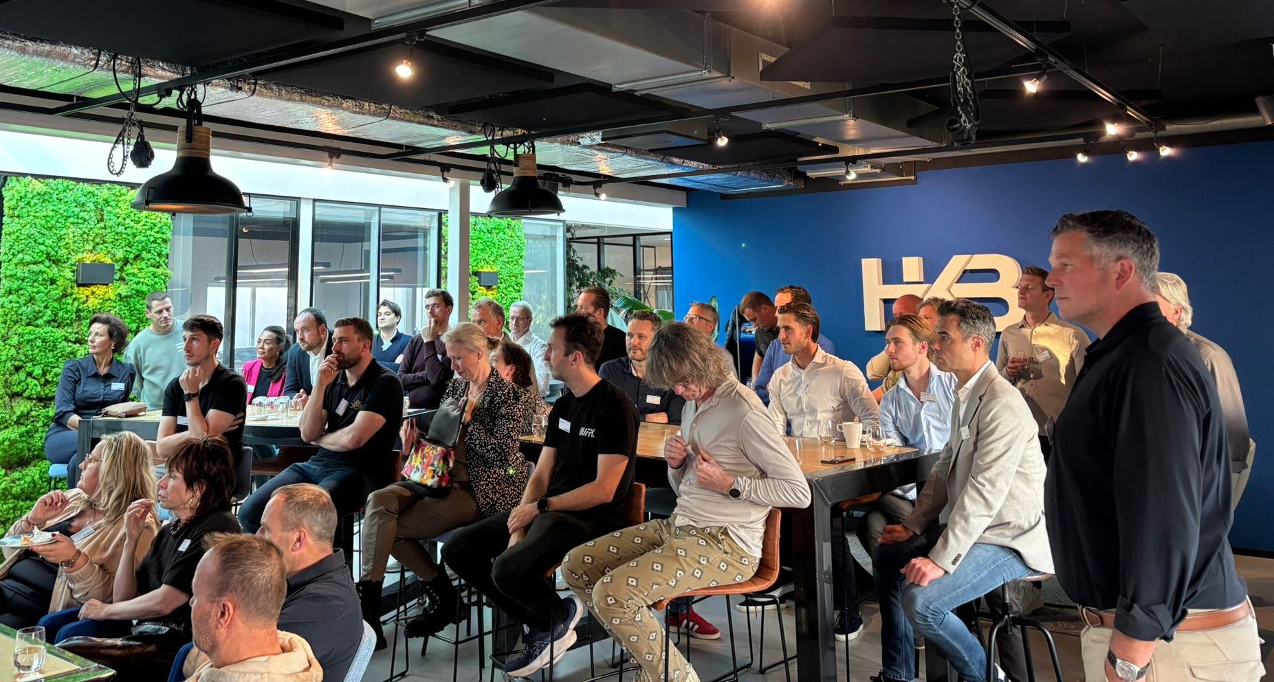 Mensen luisteren naar presentaties in moderne vergaderruimte.