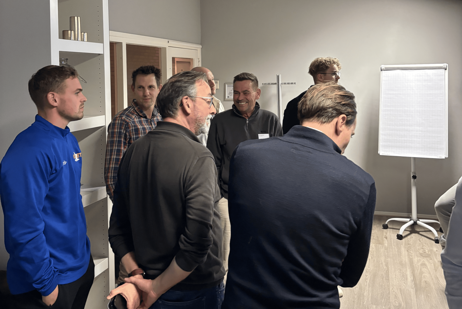 Groep mensen in vergadering bij flip-over.