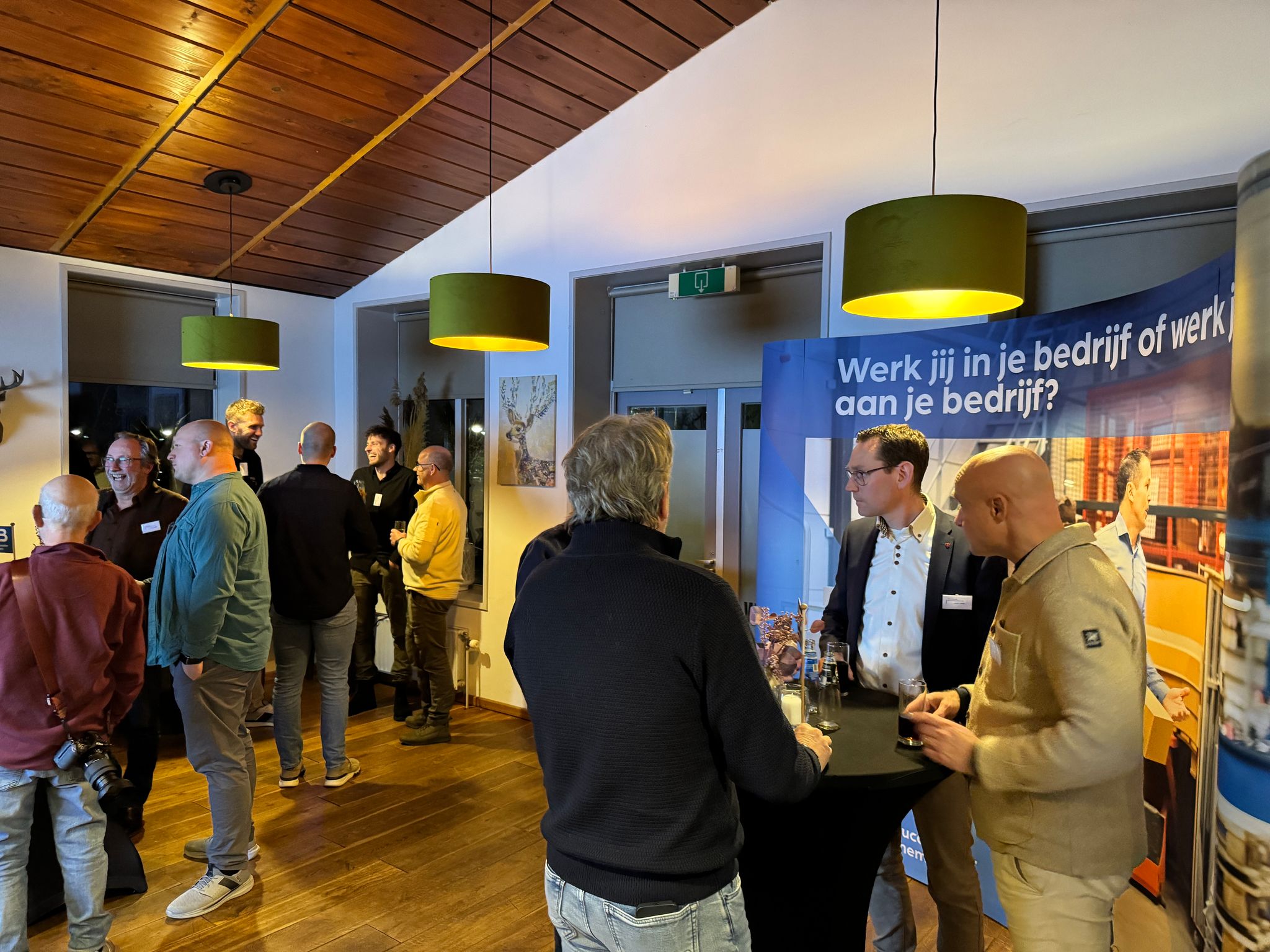 Zakelijk evenement met netwerkende mensen bij een stand.